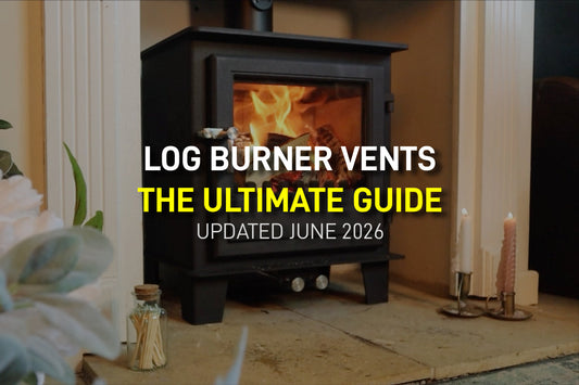 A modern black wood-burning stove with a bright fire burning inside, featuring overlay text that reads: Log Burner Vents: The Ultimate Guide. Updated June 2026.