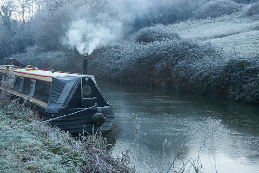 Smoke from the chimney of a narrowboat on a frosty morning