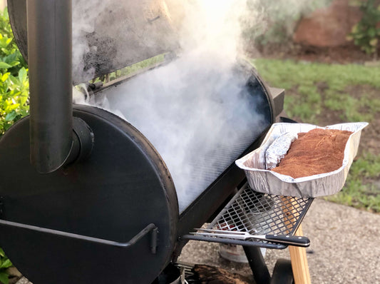 Smoker Emitting Smoke With Large Brisket Ready To Be Smoked